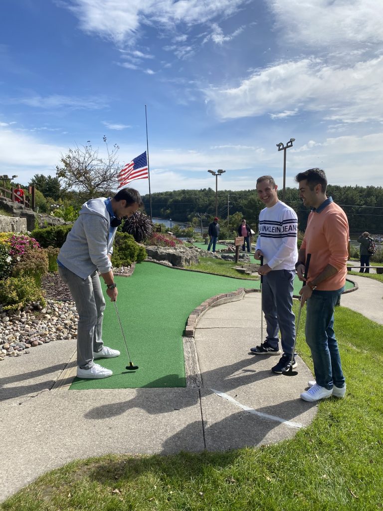 three people mini golfing